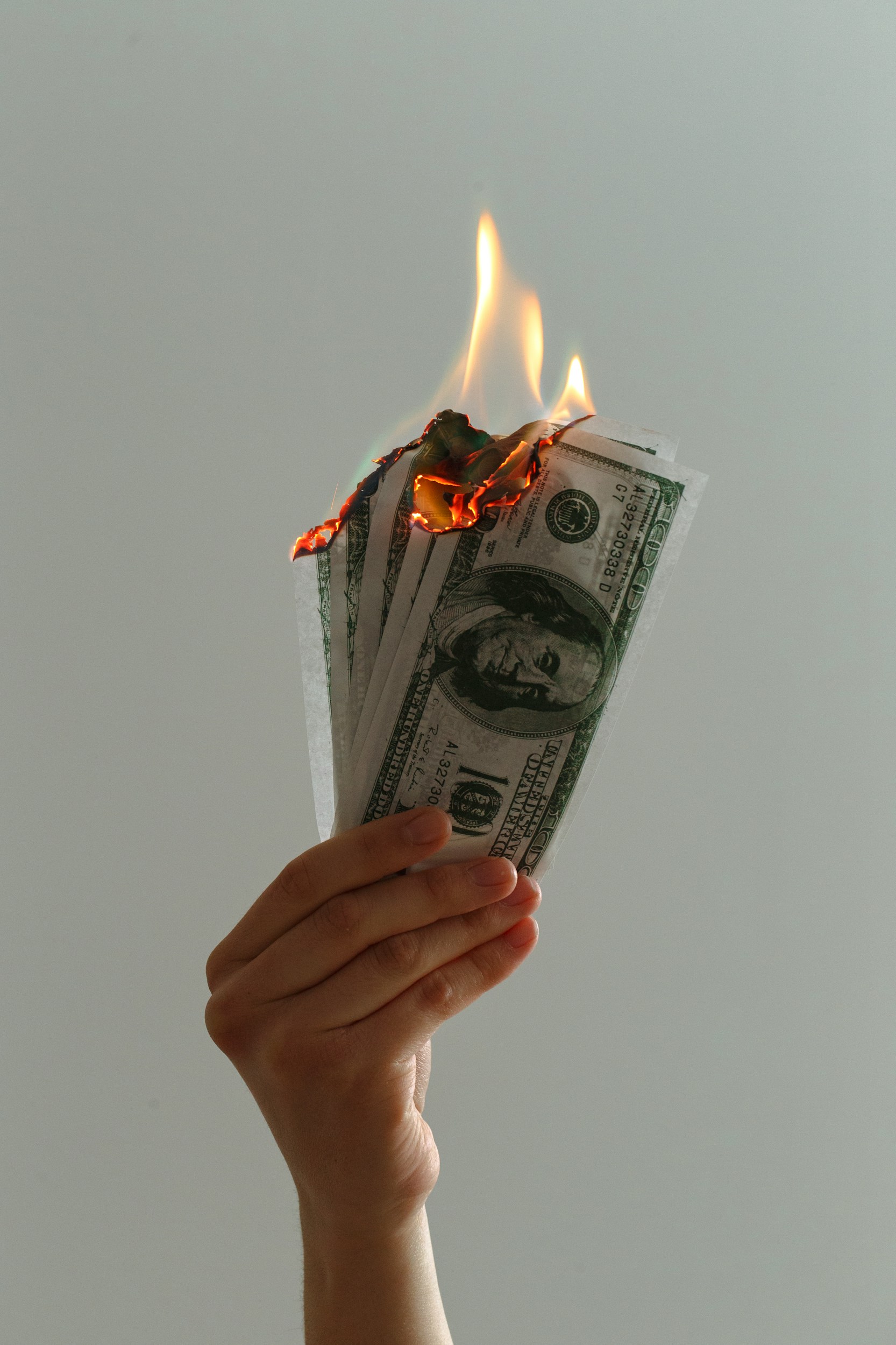 Hand holding burning money
